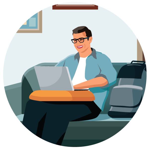 A man with glasses sitting on a couch, using a laptop to accomplish his tasks